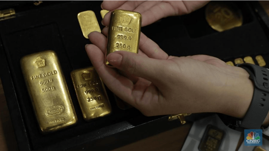 Saham, Emas, dan Kripto Kompak Melesat: Ini Penyebab Lonjakan Serentak di Tengah Ketidakpastian Global Karyawati menunjukkan batangan emas Antam 999.9 seberat 250g, 500g, dan 250g di kotak hitam, merefleksikan lonjakan harga emas.