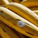 Sekelompok pisang matang dengan stiker logo.