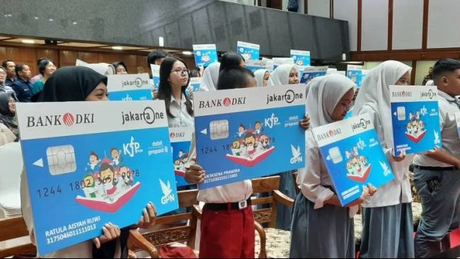 Siswa-siswi penerima Kartu Jakarta Pintar (KJP) memegang kartu Bank DKI Jakarta One, pemegang kartu KJP dapat memanfaatkan promo pangan murah Pasar Jaya.
