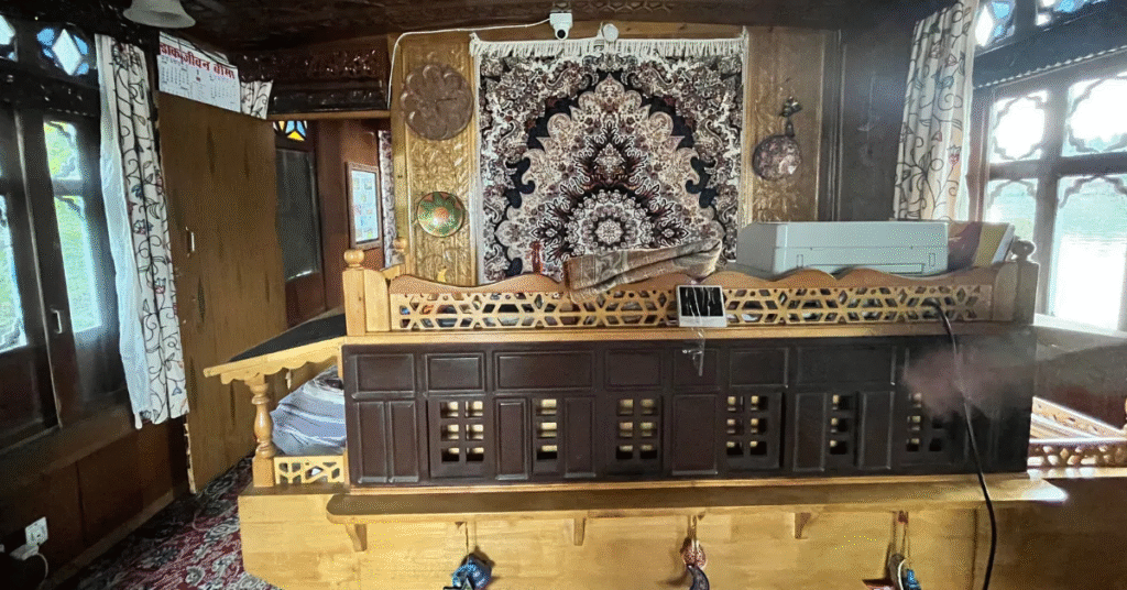 Interior rumah perahu tradisional Kashmir yang dihiasi ukiran kayu dan karpet.